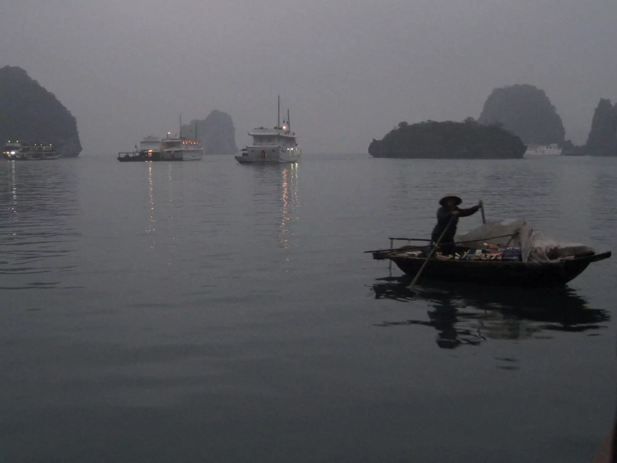 A woman sells good on a boat in Halong Bay, Vietnam