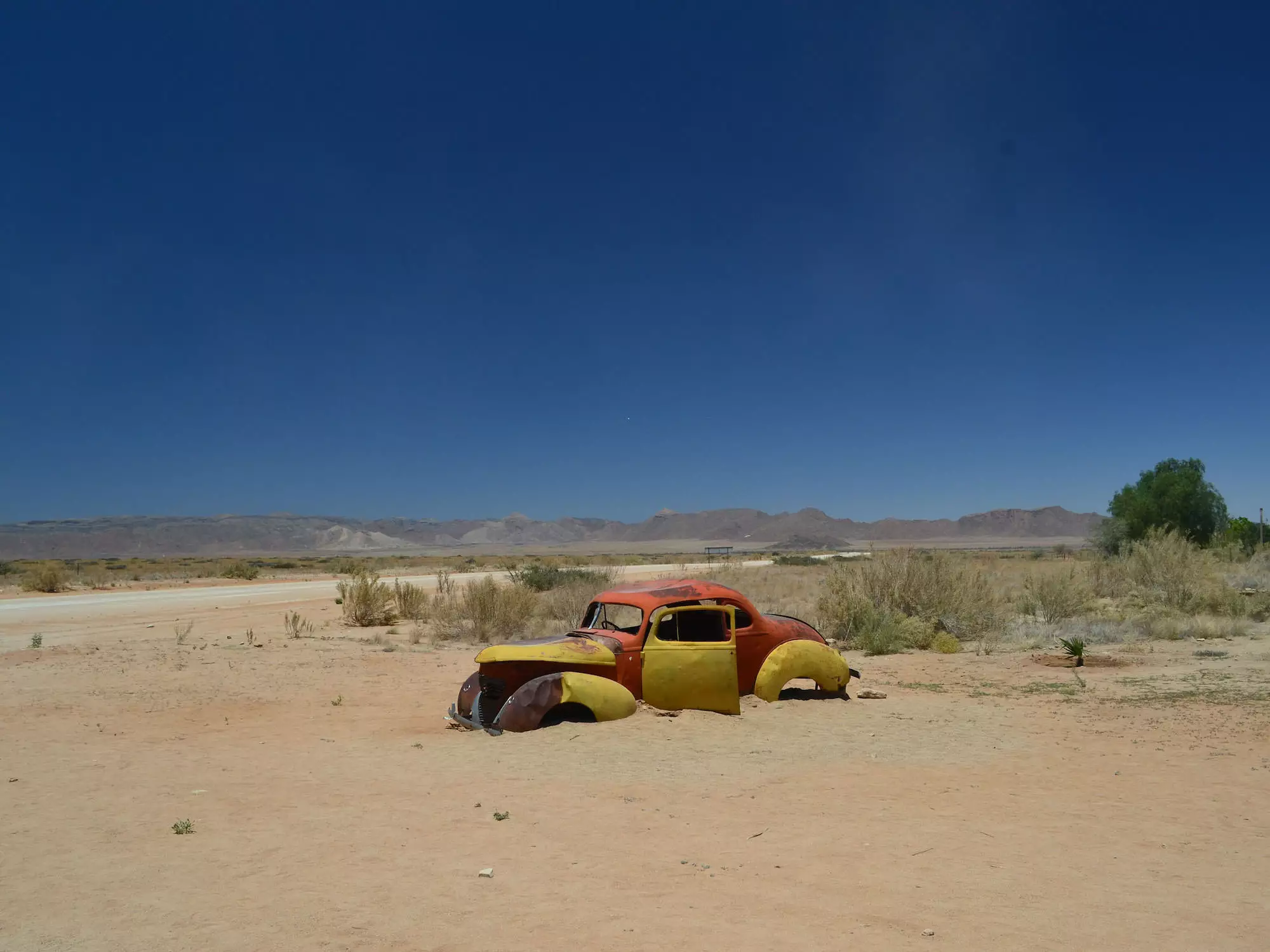 An abandoned car rusts in the desert in Solitaire, Namibia